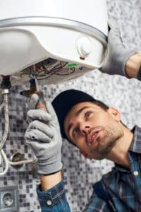 Set up boiler. Worker set up electric heating boiler at home bathroom Unterhaltsreinigung